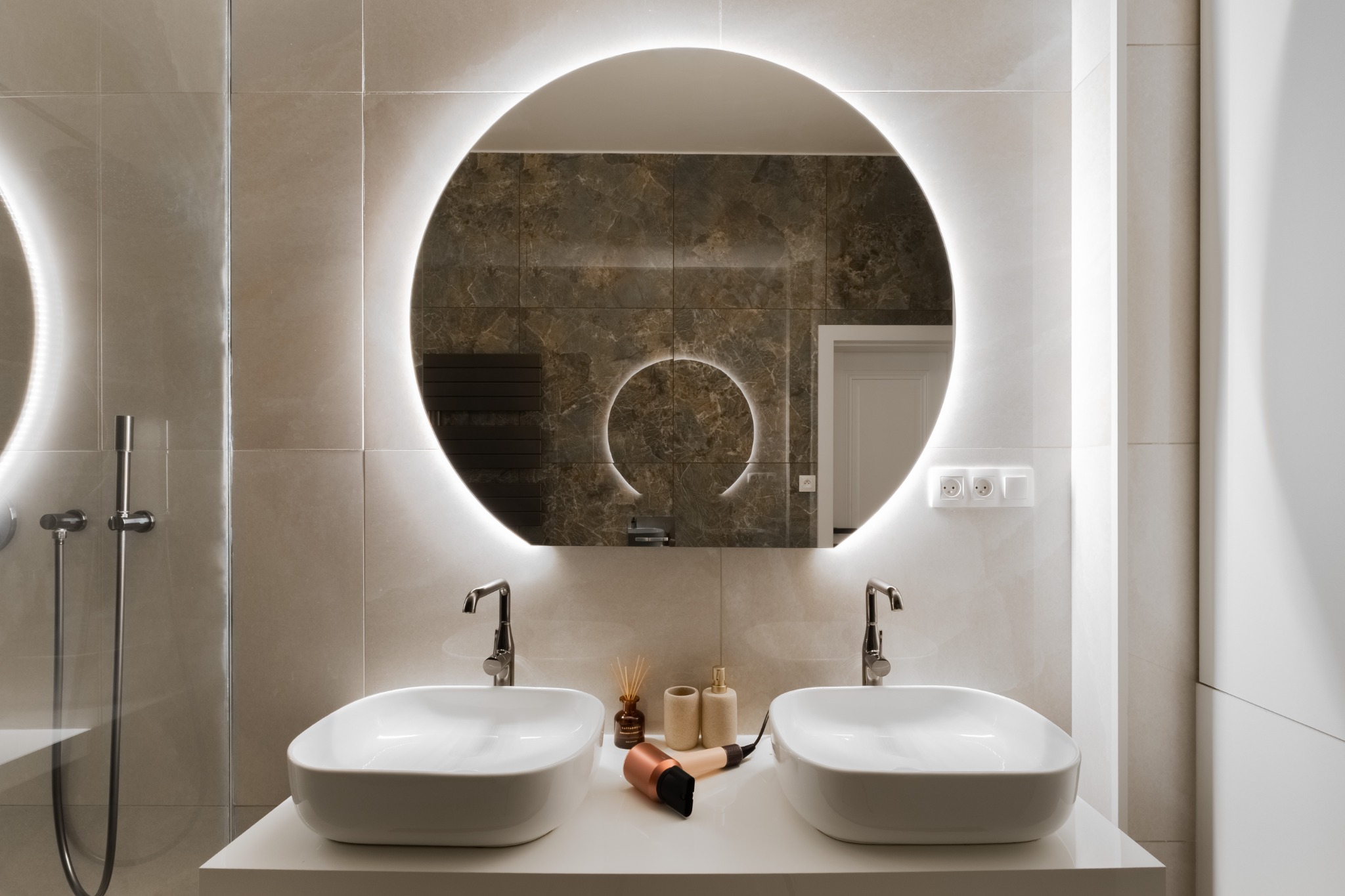 Stone bathroom with twin basins and circular mirrors